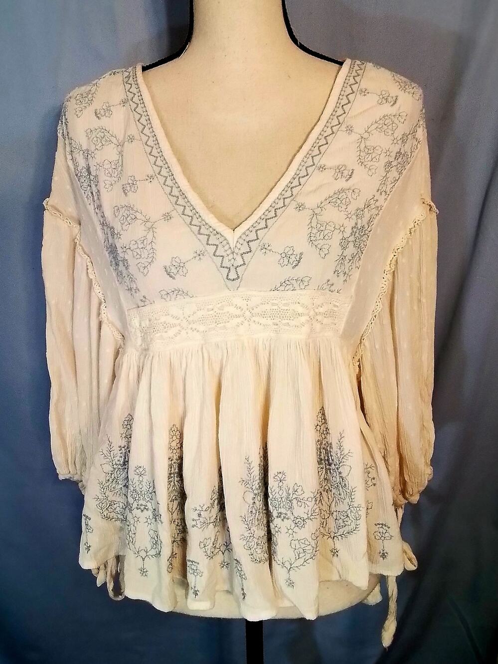 American Eagle.  Cream blouse with blue  embroidery